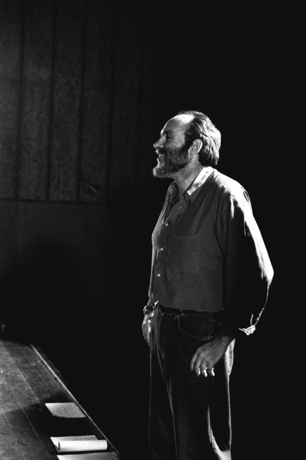 Ángel Alonso dret i de perfil a la vora de l'escenari, il·luminat lateralment sobre un fons negre